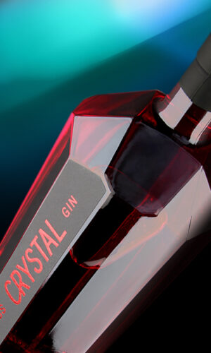 Die Crystal Gin-Flasche mit ihrem einzigartigen Design eines Kristalls. Eine transparente Flasche mit rotem Gin